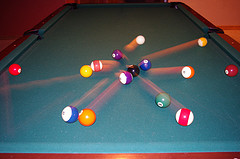 Colorful billiards balls scattered on a blue billiards table