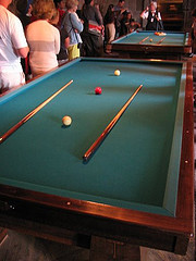 Billiards table with clear, white and red balls with cues